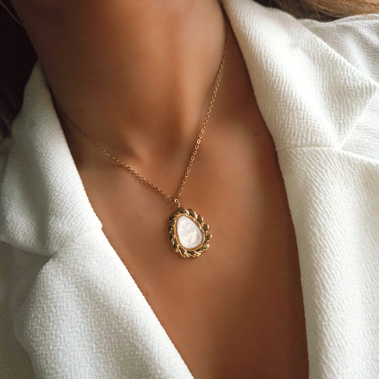 Collier doré et pierre blanche