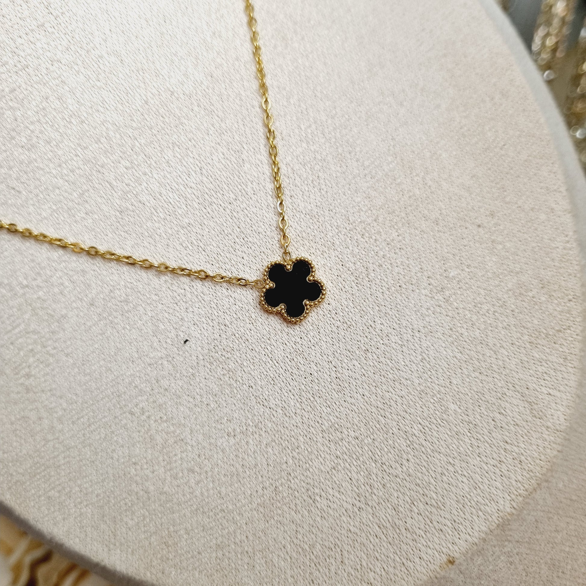 Photos du Collier avec Pendentif en Pierre Noire en Forme de Trèfle à 5 Feuilles, sur chaîne dorée en acier inoxydable plaqué or 18k. Bijou élégant et raffiné, idéal pour ajouter une touche de sophistication à toutes vos tenues.