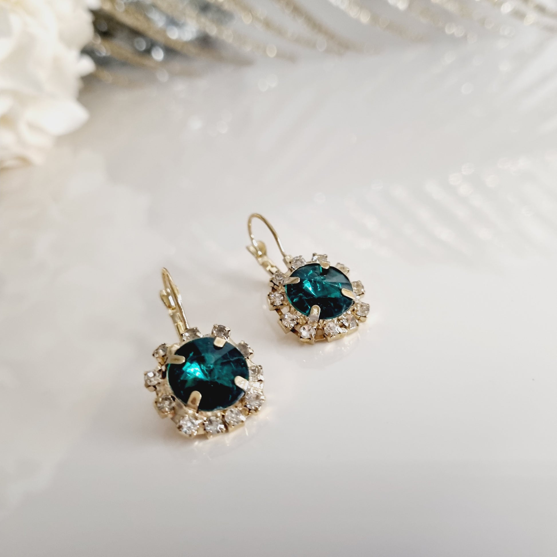 Découvrez nos élégantes boucles d'oreilles vertes et dorées, ornées d'une pierre verte éclatante entourée de strass scintillants. Parfaites pour ajouter une touche de sophistication et de glamour à n'importe quelle tenue.  Caractéristiques : - **Design** : Pierre verte entourée de strass - **Couleur** : Vert et doré - **Matériau** : Laiton  Ces boucles d'oreilles sont idéales pour les occasions spéciales ou pour apporter une touche d'élégance à votre style quotidien