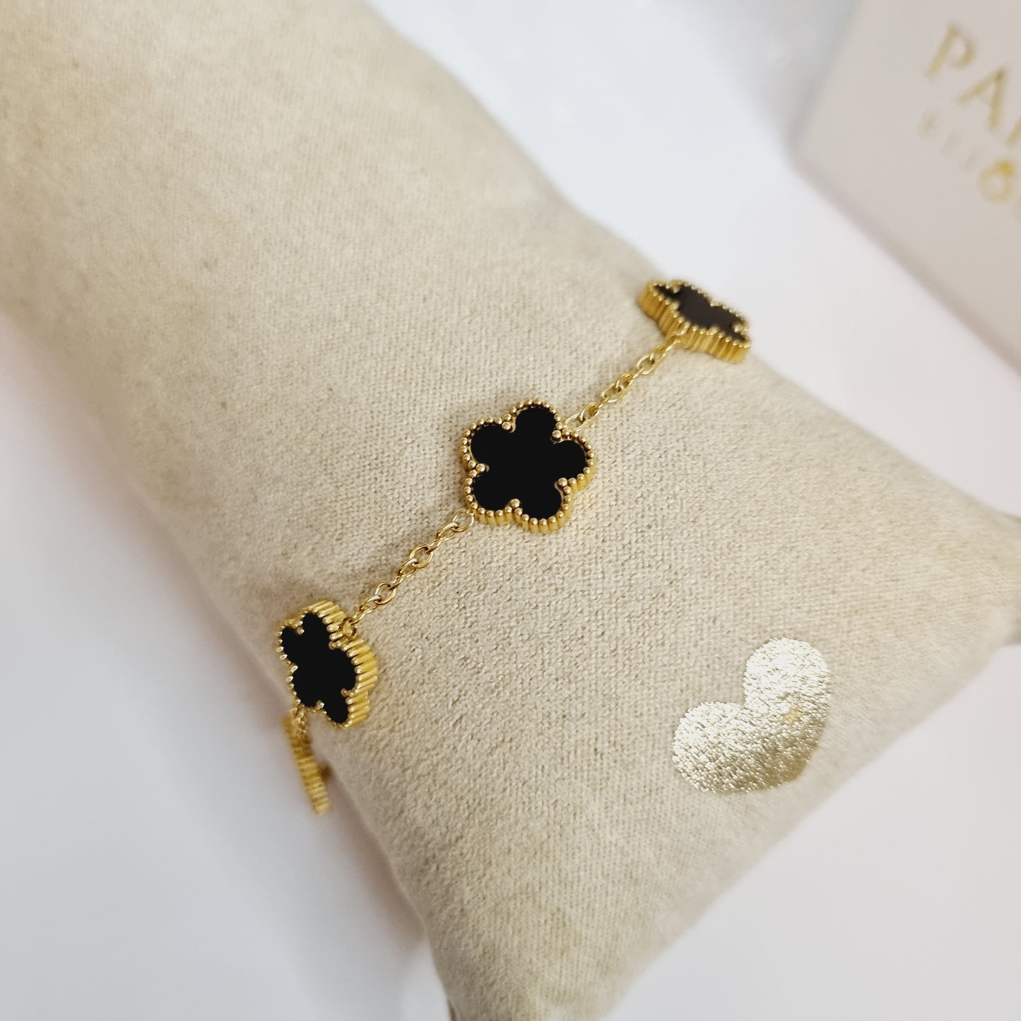 Photos du Bracelet Doré avec Pierres Noires en Forme de Trèfles à 5 Feuilles, en acier inoxydable plaqué or 18 carats. Bijou élégant et raffiné, parfait pour ajouter une touche de glamour à toutes vos tenues.