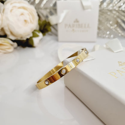 Bracelet doré posé sur son écrin cadeau. Acier inoxydable pour femme classe
