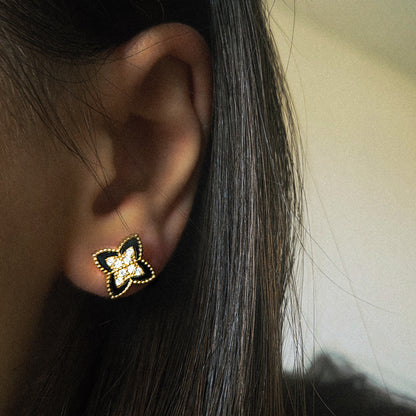 Détail de la fleur noire des boucles d’oreilles dorées