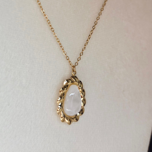 Collier doré et pierre blanche