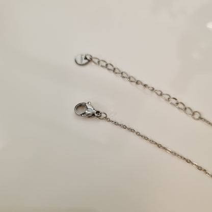 Collier en acier inoxydable couleur argent, en forme de trèfle à 4 feuilles avec strass zircons.  La longueur peut s'ajuster.  L'acier chirurgical / inox / inoxydable (peut être appelé de plusieurs manières différentes) résiste à l'eau et à tout type de liquide. Vous pouvez dormir avec, vous laver/baigner avec, faire du ménage avec sans craindre que la bague ne s'abime.  Cette matière garde son éclat au fil des années et est hypoallergénique, elle convient donc pour les personnes sujettes aux allergies. 