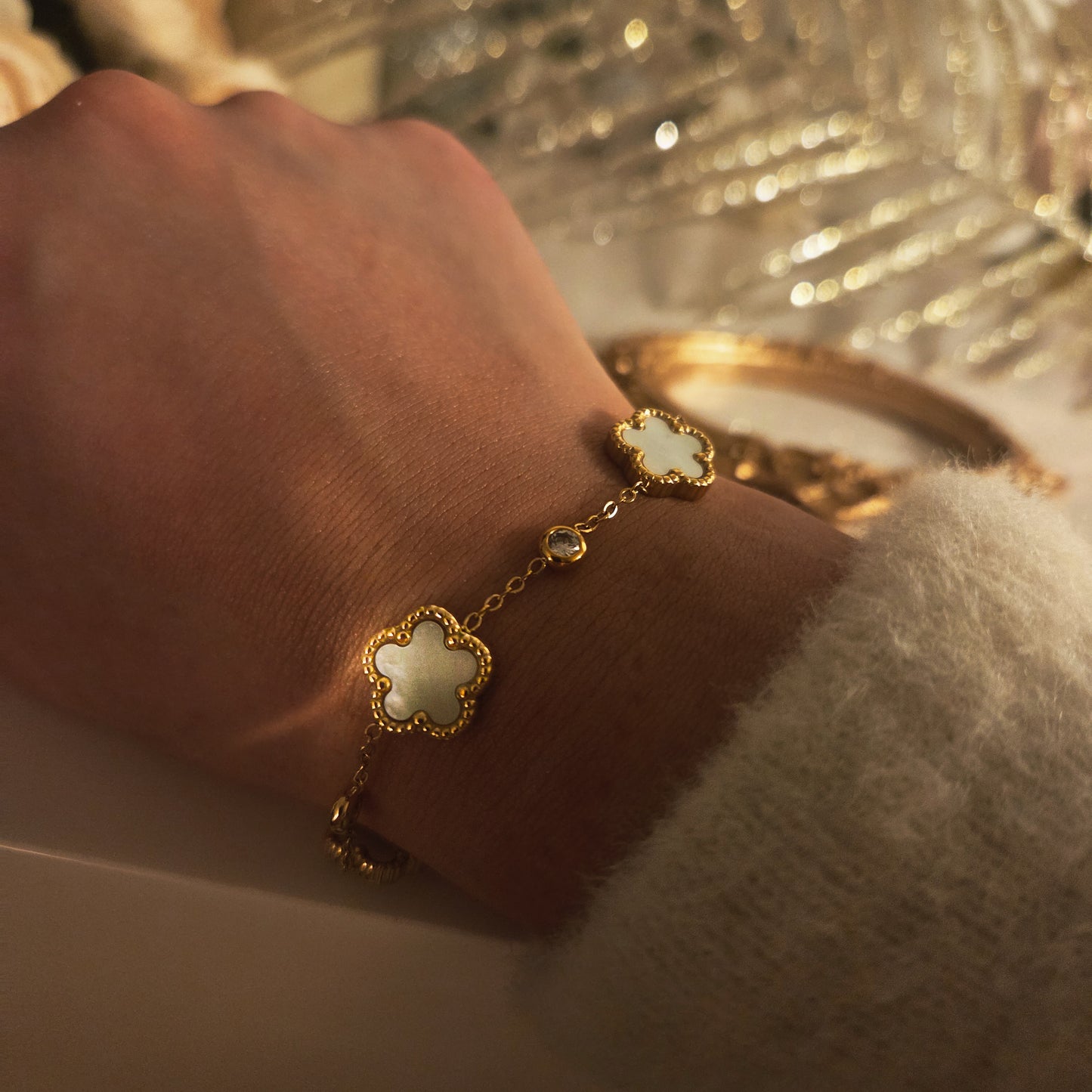 Bracelet trèfle nacré doré porté au poignet