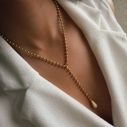 Collier Y doré en acier inoxydable porté avec pendentif goutte scintillant