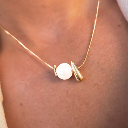 Détail du collier doré avec perle nacrée