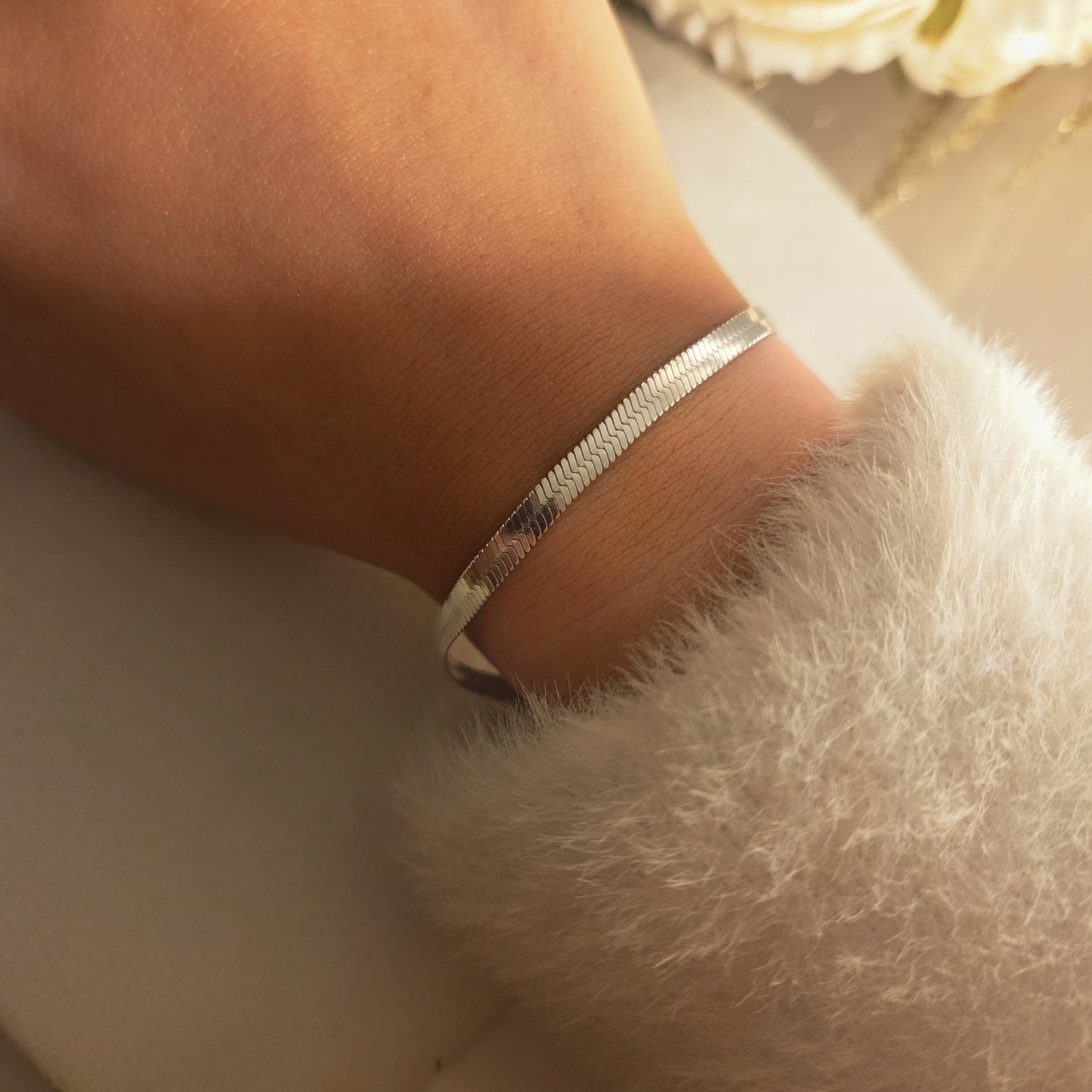 Bracelet maille plate argenté porté au poignet