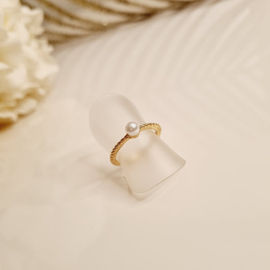 Découvrez notre bague dorée avec une perle, une pièce élégante et minimaliste fabriquée en laiton de haute qualité. Sa forme unique apporte une touche moderne et raffinée à n'importe quelle tenue. Avec sa couleur or, cette bague est parfaite pour une utilisation quotidienne ou pour des occasions spéciales.  Caractéristiques : - Matériau : Laiton et perle - Couleur : Or et blanc