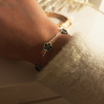 Bracelet trèfles noirs argentés porté au poignet