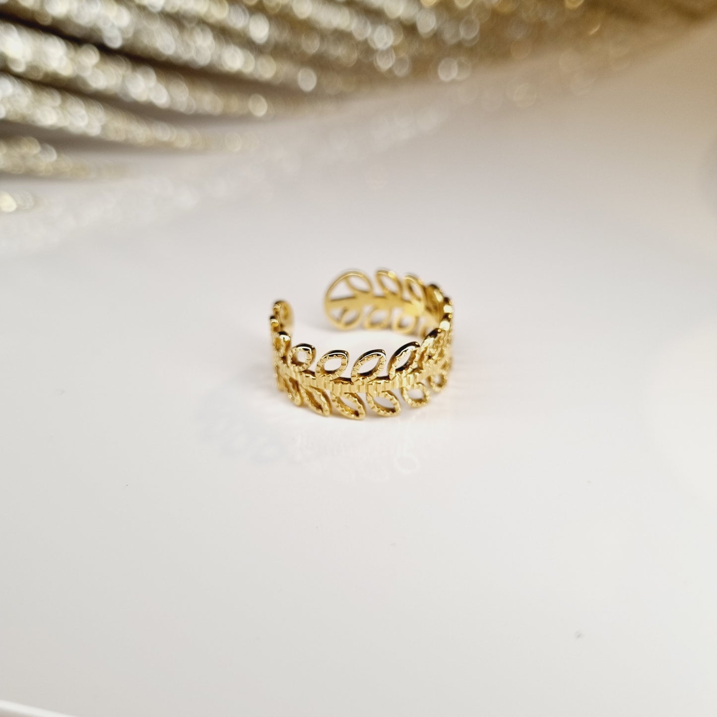 Cette bague en acier inoxydable couleur or est dotée d'un motif de laurier, symbole de victoire et de succès. Avec sa taille réglable, elle convient à tous les doigts et peut être portée au quotidien ou pour des occasions spéciales